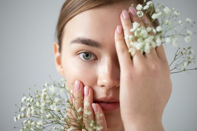 1667942083-portrait-beautiful-woman-with-clear-skin-posing-with-baby-s-breath-flowers.jpg